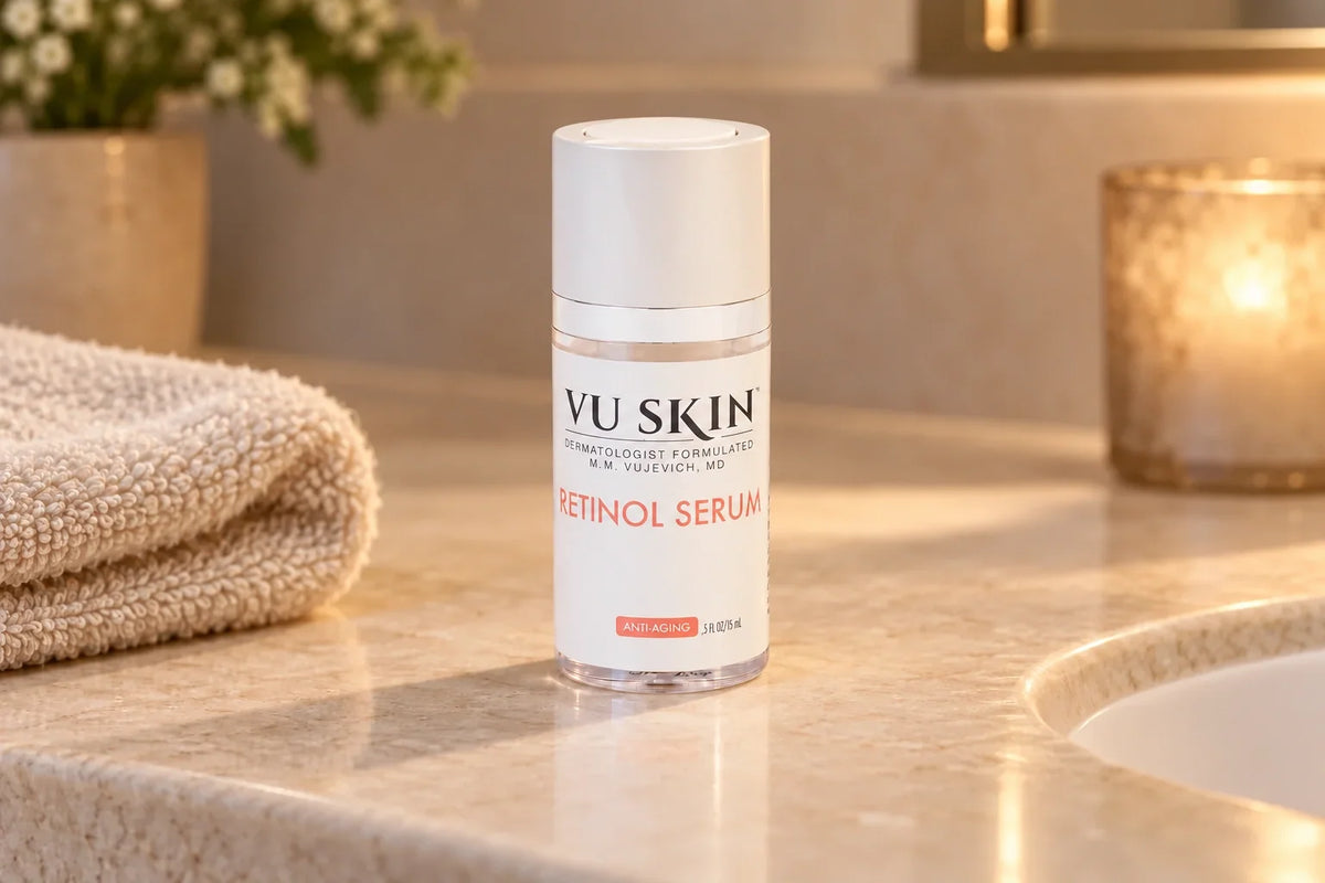 VU Skin Retinol Serum bottle on an ivory stone vanity beside a folded towel.