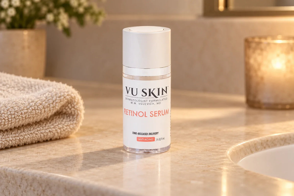 VU Skin Retinol Serum bottle on an ivory stone vanity beside a folded towel.