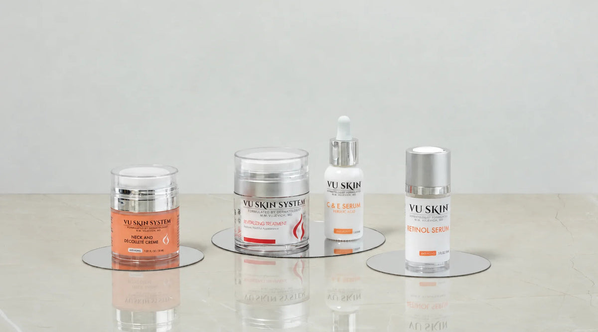 VU Neck and Decollete Creme, Revitalizing Treatment, C & E Serum and Retinol Serum on mirrored stands.